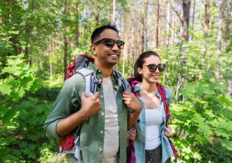 zwei menschen wandern mit sonnenbrille durch den wald